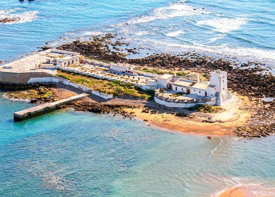 La isla escondida en Andalucía que aguarda un castillo sobre el mar