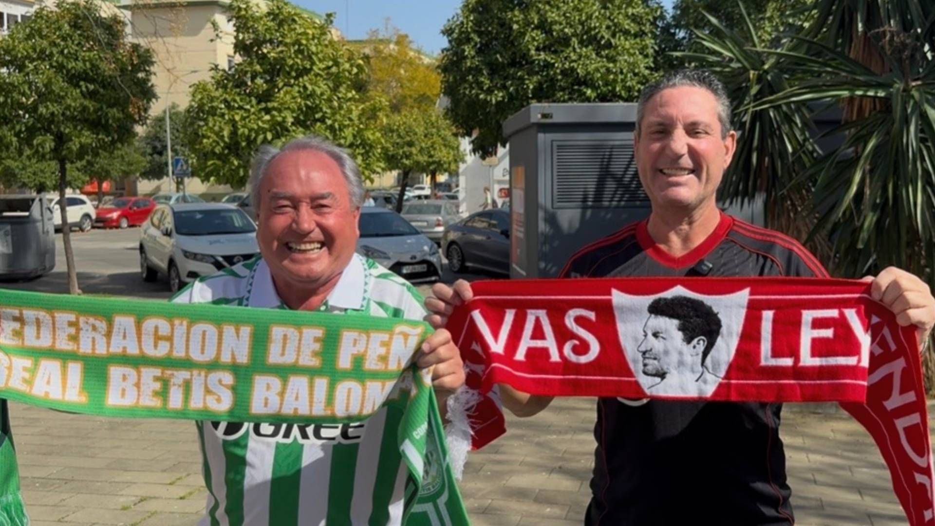 Una peña sevillista y otra bética, a escasos metros, viven con guasa sevillana la semana más importante del año