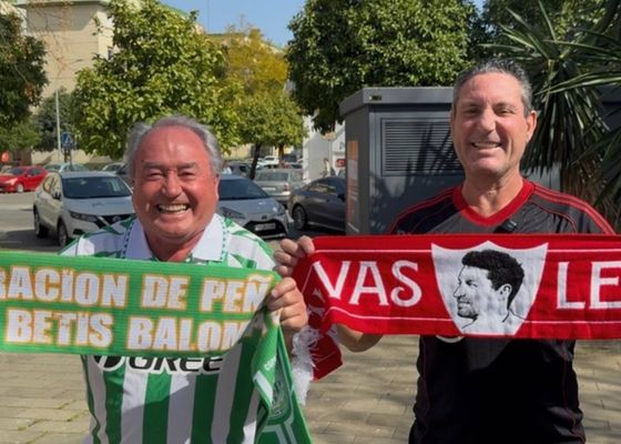 Una peña sevillista y otra bética, a escasos metros, viven con guasa sevillana la semana más importante del año